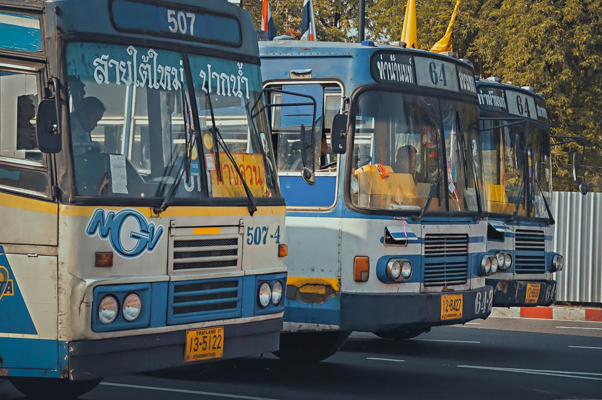 Bus public bleu et blanc stationné dans une rue animée de Chiang Mai, Thaïlande