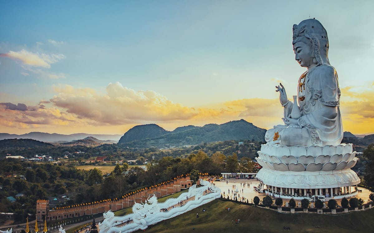 Vue panoramique sur l'immense statue de Guan Yin du Wat Huay Pla Kang à Chiang Rai, un incontournable de la Thaïlande du Nord au crépuscule.