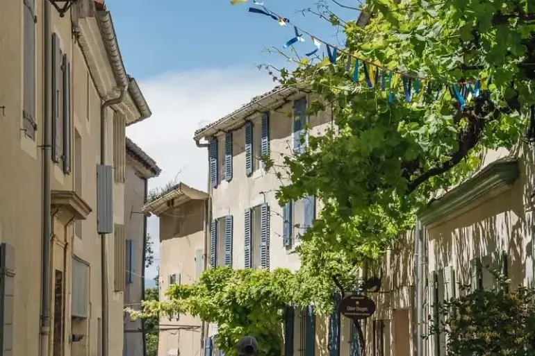 Balade dans une ruelle ornée de fanions à Pernes-les-Fontaines lors de la Mission GESTE artisans d'art