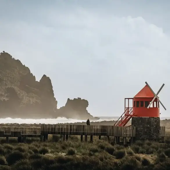 Moulin à vent rouge face aux vagues sur la côte de Pico aux Açores